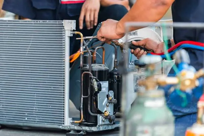 Technicians servicing residential heating and cooling equipment