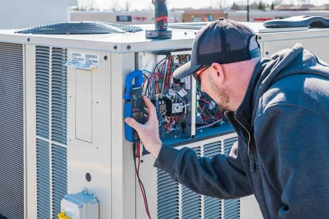 Technician diagnosing a large outdoor HVAC system